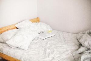 Side view of morning bed after awakening with open book and glass of lemon water photo