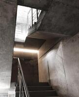 Empty cement concrete staircase with steel handrails inside of building under construction photo