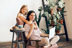 Carefree mother and daughter hugging at home photo