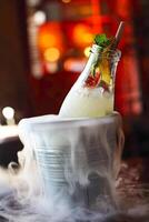 Lemonade serviced in the bottle with mint in the bucket with dry ice photo