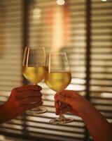 Young couple with two glasses of white wine in bed on the blurred background photo
