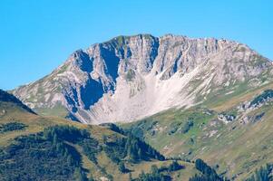 landscape in the Alps with mountains, meadows, trees photo