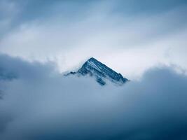 mountain peak looks out of the clouds photo