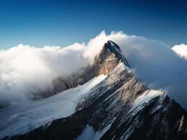 mountain peak looks out of the clouds photo