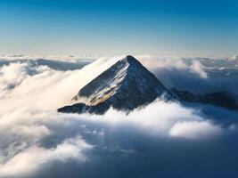 mountain peak looks out of the clouds photo