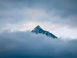 mountain peak looks out of the clouds photo