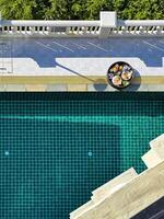 Top-down view of a delicious breakfast served poolside at a luxurious pool, showcasing the beautiful tiled design and vibrant greenery, perfect for themes of luxury living and relaxation photo