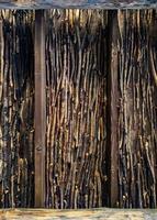 A detailed close-up of a wooden wall constructed from stacked branches, showcasing the rich textures and natural patterns. Perfect for rustic, nature, and architecture-themed projects photo