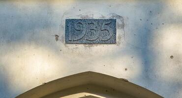 Close-up image of a stone engraving with the year 1935 on the wall of an old kirha. The weathered texture and historical significance of this detail add depth to architectural and historical themes. photo