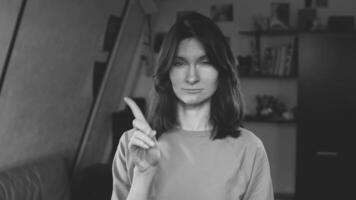 a menina mostra isto é impossível e sorri. não, não permitindo gesto. uma gesto do negação. a mulher drives a índice quadro. tabu. você não pode. monocromático. Preto e branco cenário. video