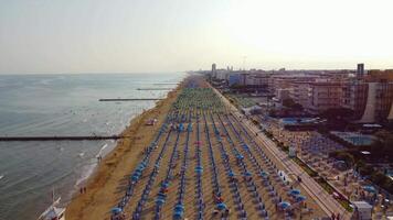 Aerial view of Jesolo beach, near Venice in Italy, coast with sunset. Adriatic Sea in the Mediterranean with beaches full of tourists on holiday and traveling in summer. Top view of umbrellas, hotels. video