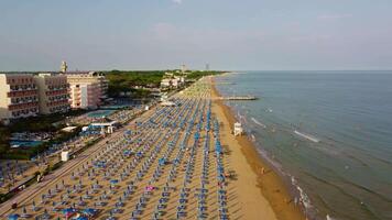 Aerial view of Jesolo beach, near Venice in Italy, coast with sunset. Adriatic Sea in the Mediterranean with beaches full of tourists on holiday and traveling in summer. Top view of umbrellas, hotels. video