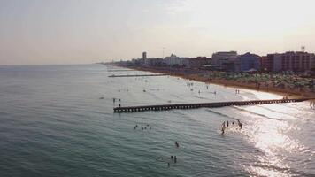 Aerial view of Jesolo beach, near Venice in Italy, coast with sunset. Adriatic Sea in the Mediterranean with beaches full of tourists on holiday and traveling in summer. Top view of umbrellas, hotels. video