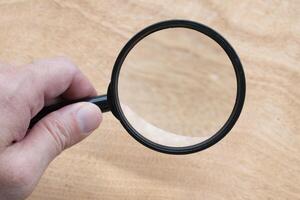 Hand holding magnifying glass with customizable space for text photo