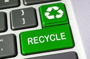 Recycle text on green laptop keyboard button. Recycle and conservation concept photo