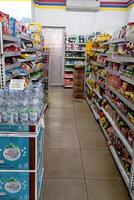 Aisle with various kinds of goods on the shelves inside Alfamart ,one of Indonesia local franchice Mini market business unit. selective Focus image. Bandung-Indonesia,February 27 2024 photo