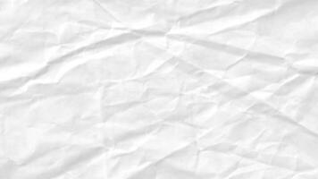 Close-up of a wrinkled white sheet of paper. The wrinkled surface is characterized by sharp creases and soft folds. video