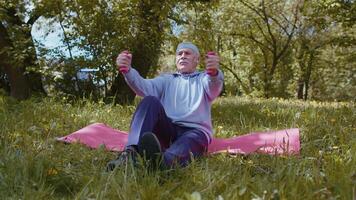Senior man exercising, making dumbbell weight lifting exercises, practicing sports training on mat video