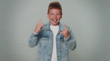 Overjoyed happy boy showing rock n roll gesture by hands, cool sign, shouting yeah with crazy face video