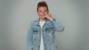 Toddler boy looking at camera doing phone gesture like says hey you call me back, contact number video