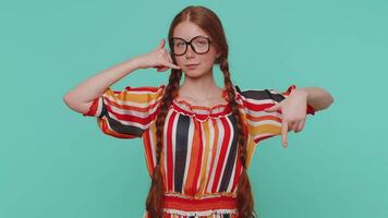 Redhead girl looking at camera doing phone gesture like says hey you call me back, contact number video