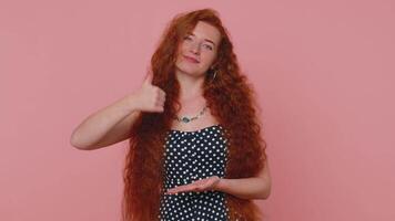 Redhead woman pointing down, saying to subscribe, gesturing ok, like, showing place for information video