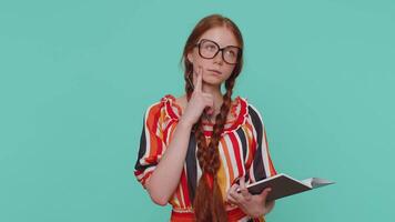 Thoughtful journalist girl making notes, writing down thoughts with pen into notepad notebook diary video