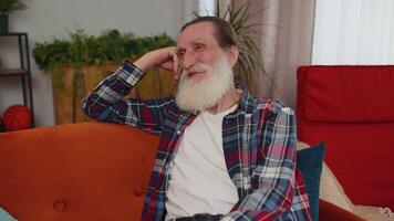 Happy calm senior man smiling dreaming resting, relaxing, good news, feel satisfied at home couch video