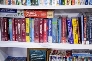 New Delhi, India, February 17 2024 - Variety of Books on shelf inside a book-stall at Delhi International Book Fair, Selection of books on display in Annual Book Fair at Bharat Mandapam complex photo