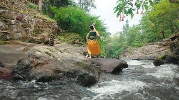 Woman in Traditional Attire by a Flowing River video