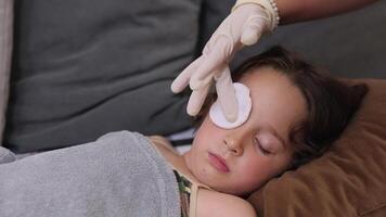 a small childhood infection on the eyelid caused by insect, mosquito or bee bites that causes swelling, redness, heat and itching. The doctor is trying to remove the swelling of the child's eye video