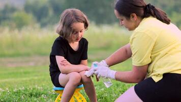 close-up photo of a mother applying cream to her child's hand after an insect, mosquito or bee bite in the summer in the yard video