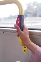 hand pressing the Bus bell switch for stop inside the public bus photo