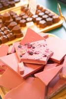 Wooden tray with magenta chocolate on a table at the event photo