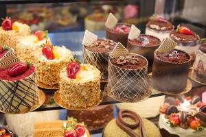 An array of pastries and eclairs are presented in the bakery display case with allure photo