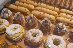 An array of pastries and eclairs are presented in the bakery display case with allure photo