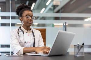 Doctor at desk using a laptop in a modern office setting, focusing on medical research and documentation. Professional work environment. photo