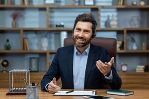Experienced mature man in a suit and headset working from a well-organized home office, exuding confidence and charisma. photo