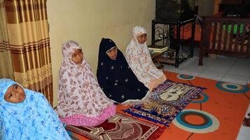 Small child learning to pray is taught directly by the teacher photo