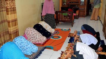 Small child learning to pray is taught directly by the teacher photo