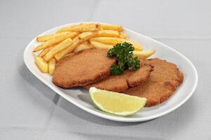 Milanese Filet Mignon with fries on a plate photo