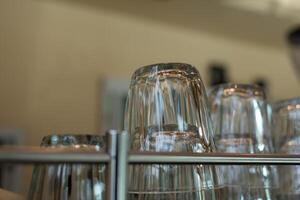 Clean glass lie upside down on a coffee machine in a cafe. Close up and selective focus. photo