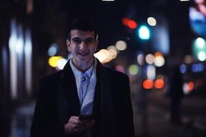 Smiling Meedle Eastern man walking down street near modern office building, photo