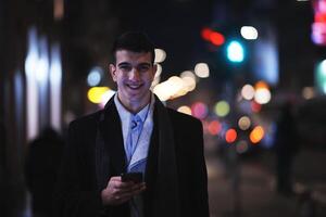 Smiling Meedle Eastern man walking down street near modern office building, photo