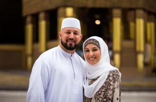 Portrait of a Muslim couple in white Ihram garments at a sacred site, reflecting their devotion and unity during pilgrimage.Generated image photo