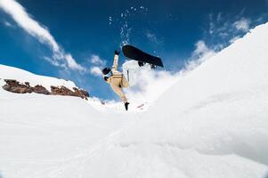 Snowboarder performs a trick in a jump, snow flies behind the athlete. Ski resort in the snow photo