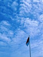 a flag flying in the wind on a sunny day photo