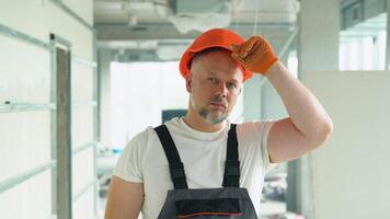 Portrait of a positive 40s builder on the construction site of the office video