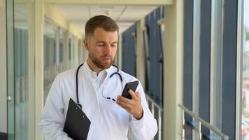 Doctor walking in a hospital corridor talking on a mobile conversation for communication planning. Calm, medical and professional in healthcare clinic in a discussion to connect video