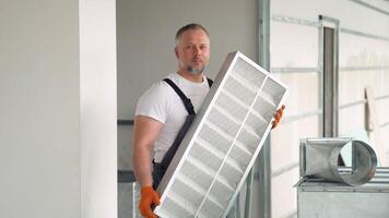 Worker holding air filter for installing in the commercial building or office ventilation system. Purity of the air concept video